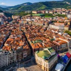 From above, Bilbao’s Old Town reveals narrow streets, red roofs and historic buildings gathered along the estuary, with Mercado de la Ribera overlooking its ancient heart.