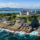 La Magdalena Palace dominates Santander’s cliffs, amid sea-carved rocks, pine groves and Cantabrian waters, with the mountainous coastline in the background.