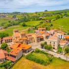 From above, Santillana del Mar reveals the village built around the Collegiate Church: terracotta roofs, medieval towers and 14th–18th-century palaces amid Cantabria’s greenery.