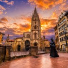At sunset, the Cathedral of San Salvador dominates the heart of Oviedo: its Gothic tower rises above the square beside La Regenta, a literary symbol of the Asturian city.