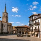 Plaza de la Constitución reveals historic Comillas through traditional houses, wooden balconies, the 1775 Old Town Hall and San Cristóbal Church, begun in 1648.
