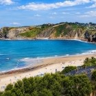 Comillas Beach opens onto the Cantabrian Sea, with golden sand, blue waters and green cliffs, offering a scenic walk along one of the coast’s most beautiful stretches.