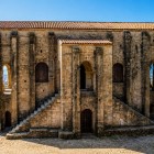 Santa María del Naranco, seen from a striking side view, evokes 9th-century Oviedo through stone arches and stairways, a Pre-Romanesque masterpiece of the Kingdom of Asturias.