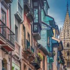 Calle Mon, the ancient street of blacksmiths, climbs between colourful façades, iron balconies and Asturian bay windows, guiding the eye towards Oviedo Cathedral’s Gothic tower.