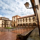 Plaza Feijoo houses the 18th-century Faculty of Psychology, distinguished by arcades, iron balconies and sober lines recalling the former Benedictine complex.