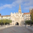 The Santa María Bridge leads to the monumental 16th-century gateway of Burgos; beyond its statues of Castilian rulers rises the Gothic Cathedral.