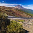 Mount Teide dominates Tenerife’s volcanic landscape, amid reddish lava fields, expanses of Teide broom and Canary Island pine forests, along the scenic road crossing the national park.