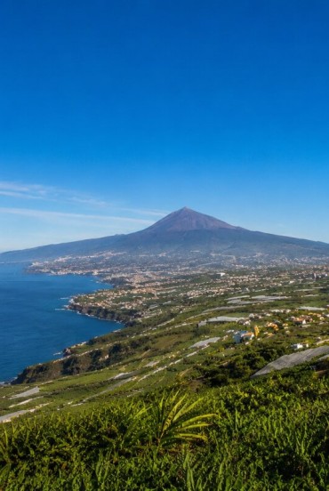 The fertile Orotava Valley slopes gently towards the Atlantic, amid palm groves, cultivated fields and Canarian villages, dominated by the unmistakable volcanic silhouette of Mount Teide.