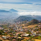 The city of San Cristóbal de La Laguna stretches across the valley among neighbourhoods, colourful houses and cultivated fields, framed by Tenerife’s mountains on the horizon.