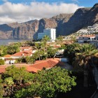 From Puerto de Santiago, the view sweeps across tropical gardens and terracotta rooftops towards the towering Los Gigantes cliffs, sculpted above the Atlantic.