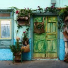 In Calle Tentenecio, a traditional single-storey Canarian house enchants with its turquoise façade, wooden frames and weathered door, surrounded by flowers and plants: an authentic corner of Garachico.