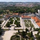 The aerial view of the National Palace of Queluz reveals the elegant harmony between its Rococo wings and French-style gardens, shaped by geometric hedges, fountains and scenic avenues.
