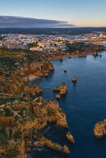Aerial view of Lagos, where the golden cliffs of Ponta da Piedade plunge into the Atlantic among sea stacks, hidden coves and the sunlit Algarve coastline.