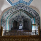 Inside the Pakhlavan Mahmud Mausoleum, the revered tomb is framed by an elegant arch covered with blue and turquoise majolica tiles, in the spiritual heart of Khiva.
