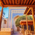 In the Ishrat-Khauli of Tash-Khauli Palace, the audience courtyard of the Khans of Khiva enchants with monumental iwans, blue majolica tiles and refined carved wooden columns.
