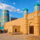 The Kuhna Ark, the ancient citadel of the khans of Khiva, unfolds among imposing walls and crenellated towers: brickwork, portals and turquoise domes evoke the power of Itchan Kala.