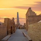 Among the alleys of Itchan Kala, the Islam Khoja Minaret rises 56.6 metres high: brickwork and turquoise tiles make it an elegant icon of early 20th-century Khiva.
