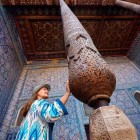 At Tash-Khauli Palace in Khiva, admire the extraordinary carved wooden column: geometric and floral motifs blend with the blue majolica tiles, an expression of the refined art of the Khanate.