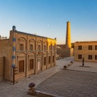 The Juma Mosque in Khiva captivates with its austere architecture: a hypostyle hall supported by ancient carved wooden columns, immersed in an evocative half-light.