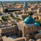 The turquoise dome of the Pakhlavan Mahmud Mausoleum dominates Itchan Kala, surrounded by madrasas, minarets and ochre-colored walls, offering a striking view over the historic heart of Khiva.