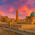 The Kalyan Minaret rises above the turquoise domes of the Mir-i-Arab Madrasa, creating one of the most iconic sights of the ancient Silk Road in the heart of Bukhara.