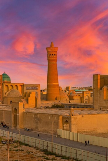 The Kalyan Minaret rises above the turquoise domes of the Mir-i-Arab Madrasa, creating one of the most iconic sights of the ancient Silk Road in the heart of Bukhara.