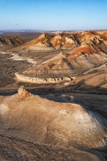 In the Kyzylkum Desert, between Khiva and Bukhara, wind-sculpted formations and ochre hues reveal the authentic face of the ancient Silk Road.