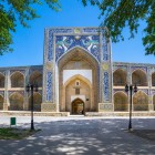 The façade of the Nadir Divan-Begi Madrasa welcomes travellers with its grand portal, simurghs and decorated loggias, reflecting 17th-century Bukhara.