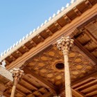 Inside the Ark of Bukhara, the portico captivates with its refined painted wooden ceiling, supported by elegant carved columns, a remarkable example of Uzbek decorative art.