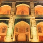 The Mir-i-Arab Madrasa reveals the elegance of Bukhara’s Islamic architecture in its inner arcades, with pointed arches, exposed brickwork and niches illuminated by warm tones.