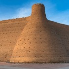 The imposing walls of the Ark of Bukhara, shaped in brick and punctuated by towers, tell centuries of history and enclose the ancient fortified citadel of the emirs.