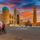 The Kalyan Mosque, rebuilt in the 16th century, welcomes visitors with its vast courtyard, arcaded galleries and blue dome, the spiritual heart of historic Bukhara.