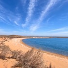 In the Kyzylkum Desert, Lake Aydarkul meets a long golden beach: blue waters and shrub-dotted dunes create a surprisingly beautiful natural landscape.