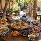 In a family-run restaurant in Nurata, travelers discover Uzbek hospitality while enjoying plov, shurpa, samsa, non bread, achichuk, dried fruit and green tea.