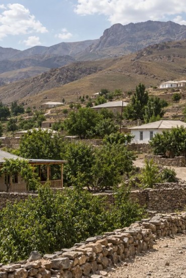 Following the path through Ukhum, travelers encounter stone and earthen houses, vegetable gardens and fruit trees: a close-knit community nestled among the arid Nuratau Mountains.