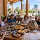After visiting the Registan, the tour pauses for lunch at a restaurant, enjoying Uzbek cuisine and a convivial moment before continuing to explore Samarkand.