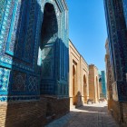 Entering the complex, the route narrows between monumental portals and mosaic-covered walls. Each passage reveals new mausoleums and different decorative styles.
